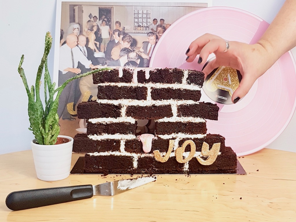 Beer chocolate cake built as a wall next to Idles Joy as an act of resistance vinyl record