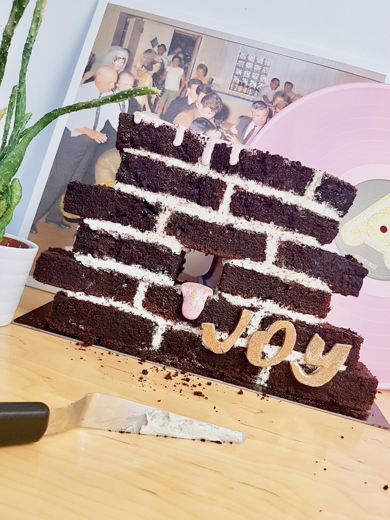 Beer chocolate cake built as a wall next to Idles Joy as an act of resistance vinyl record