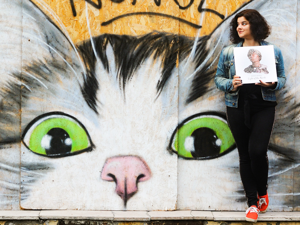 Audrey holding Miaoux Miaoux vinyl in front of cat streetart in Bordeaux