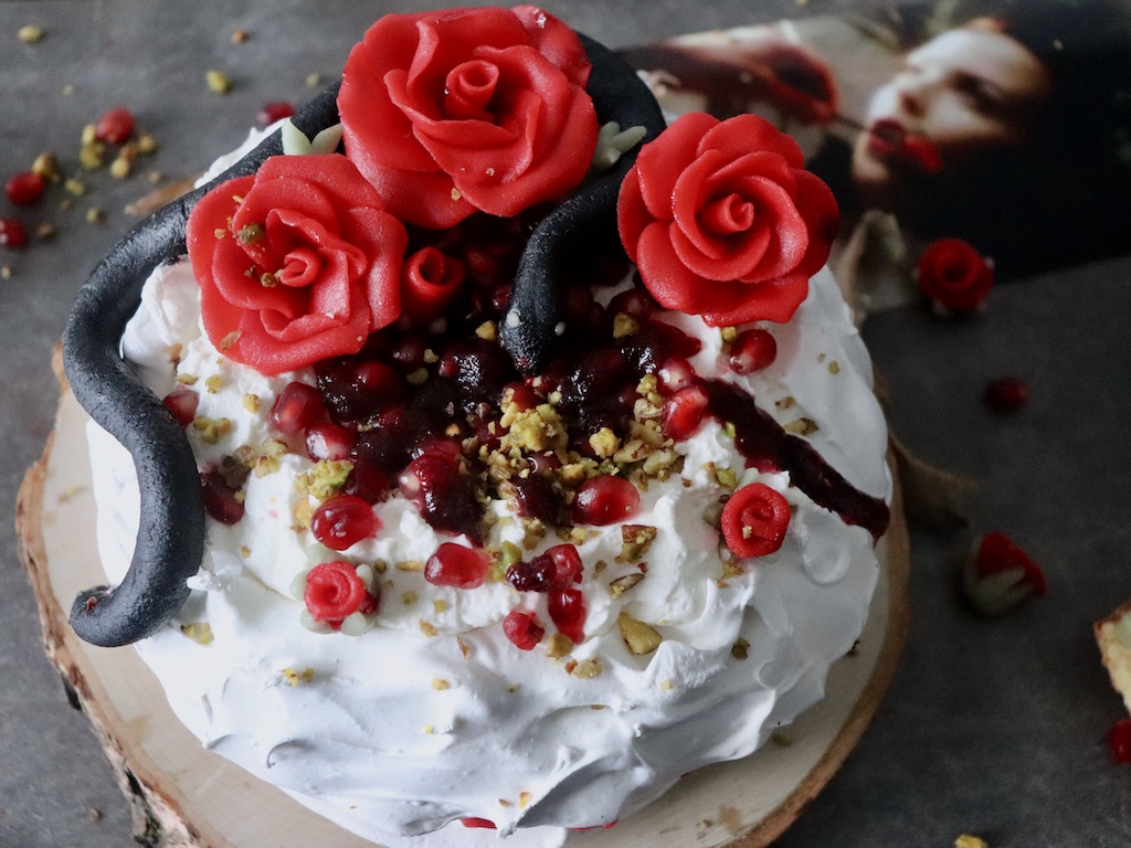 Pavlova topped with pomegranate marzipan snake and roses