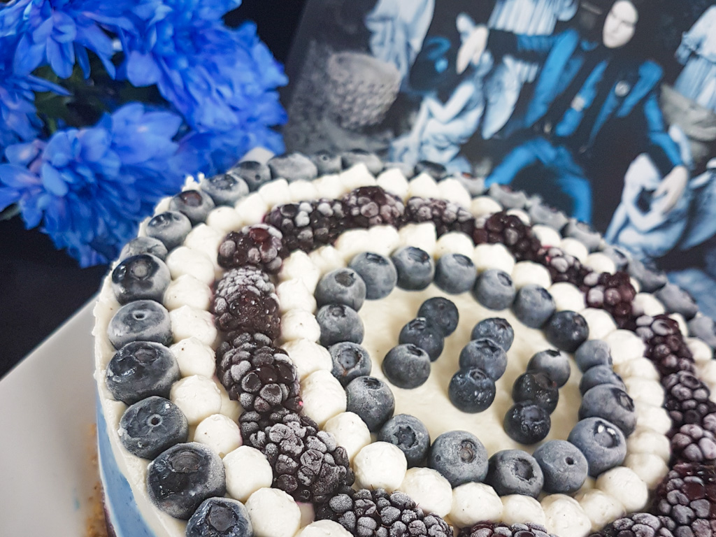 Graphic blue and white cheesecake topped with blueberries and blackberries next to Jack White Lazaretto vinyl