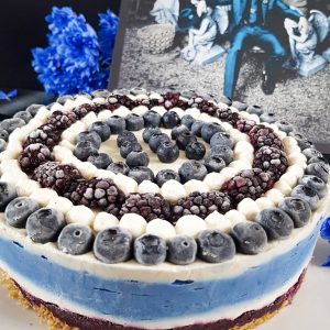 Graphic blue and white cheesecake topped with blueberries and blackberries next to Jack White Lazaretto vinyl
