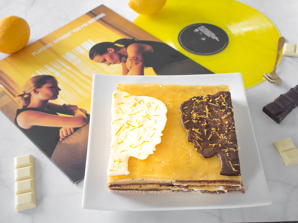 Lemon opera cake cut with chocolate faces next to Placebo Without You I'm Nothing vinyl record