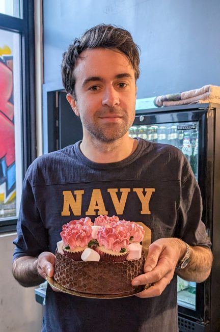 Justin Young from The Vaccines holding a cake