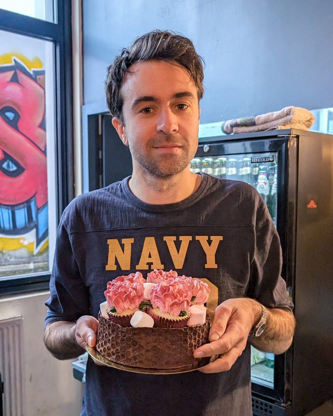 Justin Young from The Vaccines holding a cake