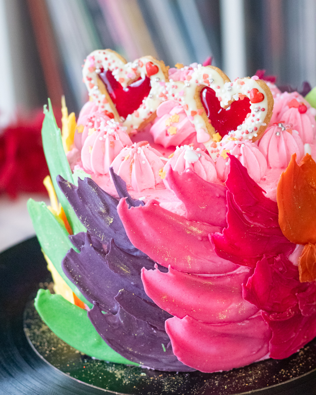 Elton John inspired rainbow cake covered with chocolate feathers