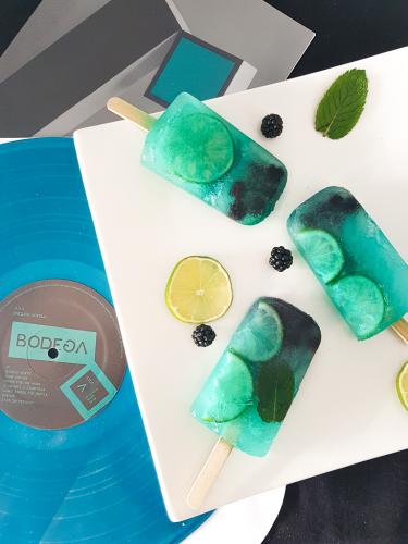 Mint lime and blackberries popsicles next to Bodega Endless Scroll vinyl record