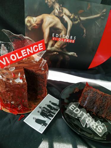 Chocolate layer cake with edible glass next to Editors Violence vinyl record