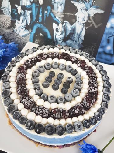 Graphic blue and white cheesecake topped with blueberries and blackberries next to Jack White Lazaretto vinyl