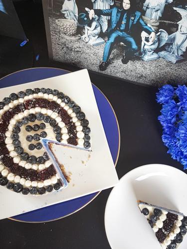 Graphic blue and white cheesecake topped with blueberries and blackberries next to Jack White Lazaretto vinyl