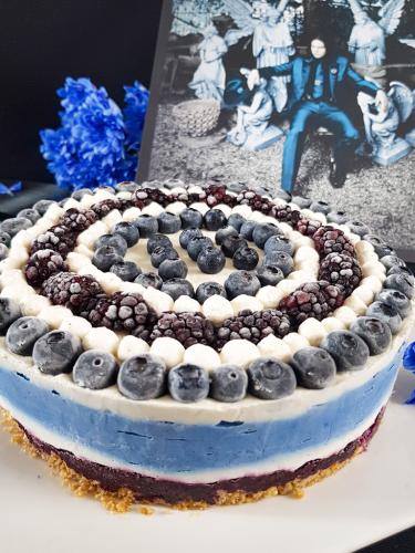Graphic blue and white cheesecake topped with blueberries and blackberries next to Jack White Lazaretto vinyl