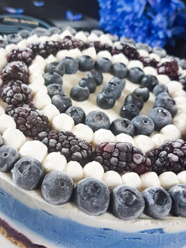Graphic blue and white cheesecake topped with blueberries and blackberries