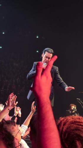 Nick Cave on stage in Paris 2024 with a red right hand