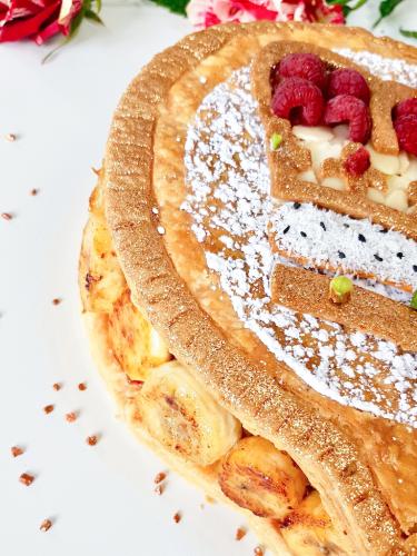 Galette des rois topped with crown design filled with caramelized bananas close up