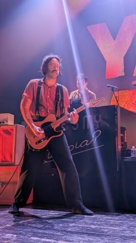 Sam Shipstone on stage with Yard Act